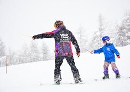 Uno snowboarder sta prestando attenzione al maestro di snowboard durante una delle Lezioni private di snowboard - Tutte le età e livelli organizzate dalla scuola di sci YES Academy Sestriere.