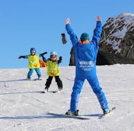 Ein Skilehrer des ESI Glycérine ermutigt junge Skifahrer beim ersten Schneepflug während eines Kinder-Skikurses in Anzère.