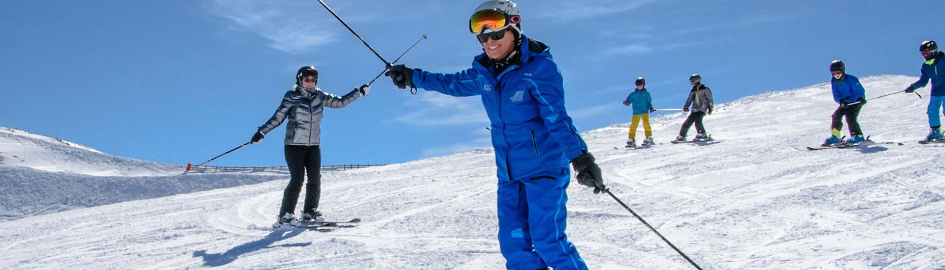 Während des Skikurses für Erwachsene für Anfänger bei der Schneesportschule Wildkogel zeigt ein Skilehrer der Gruppe, wie man Kurven fährt und das Gleichgewicht auf den Skiern hält.