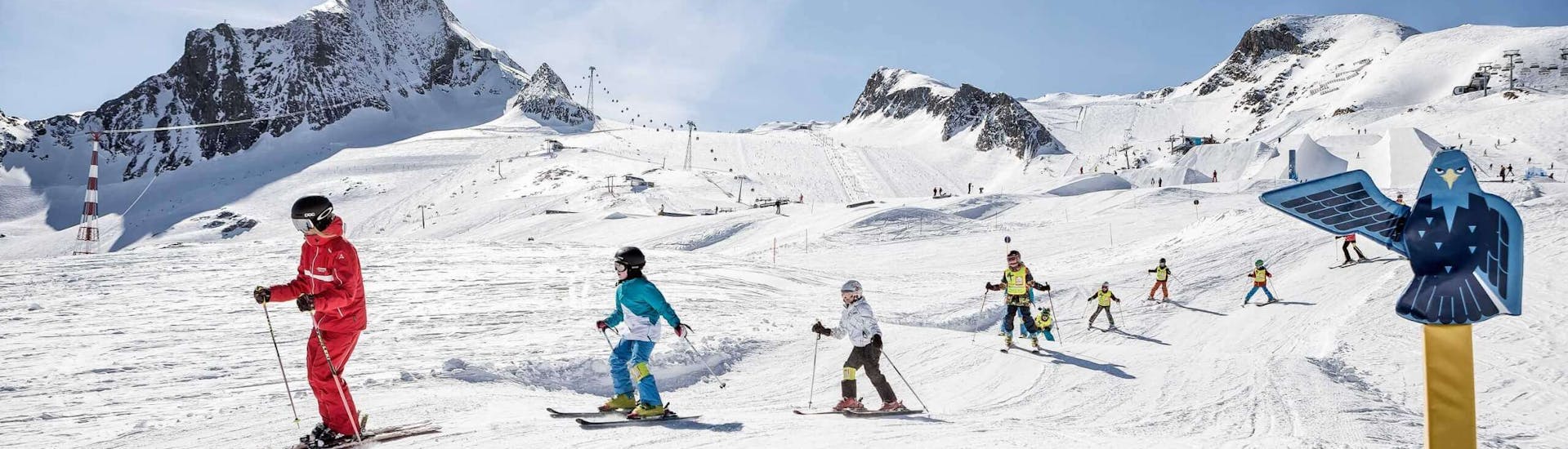 Eine Gruppe von Kindern fährt während des Kinder-Skikurses "BOBOs Kids Club" (4-15 J.) für Fortgeschrittene mit dem Ski Dome Viehhofen die Pisten hinunter.