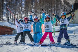 Les enfants et le moniteur de ski prennent une photo pendant l'un des cours particulier de ski pour enfants pour les skieurs expérimentés à Sauze d'Oulx. 