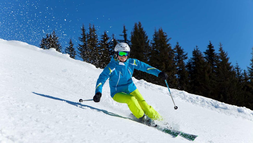Een skiër glijdt van een helling tijdens volwassen skilessen voor gevorderden bij skischool Ski Dome Viehhofen.