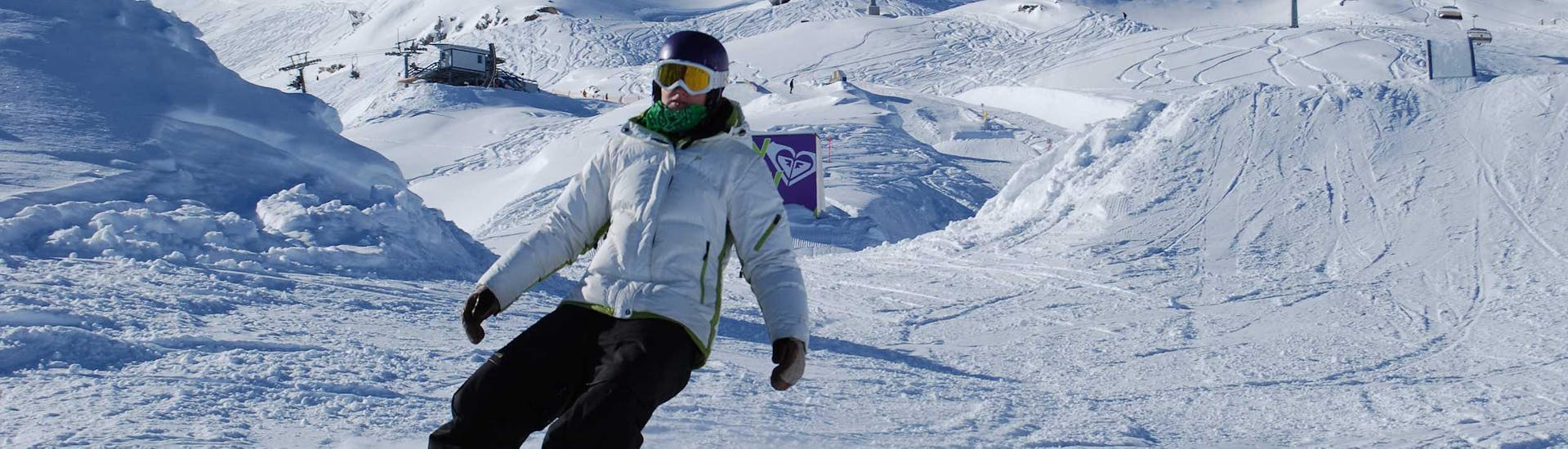 A snowboarder on the slopes during adult snowboarding lessons for beginners with ski school Ski Dome Viehhofen.