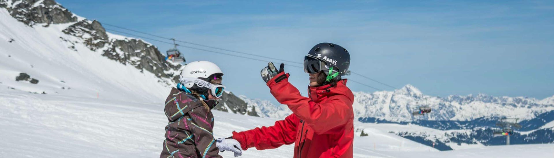 An instructor teaching a pupil during snowboarding lessons "All-in-One" for beginners with Ski Dome Viehhofen.