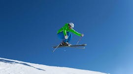 Een skiër vliegt door de lucht tijdens privé skilessen voor volwassenen van alle niveaus bij skischool Ski Dome Viehhofen.