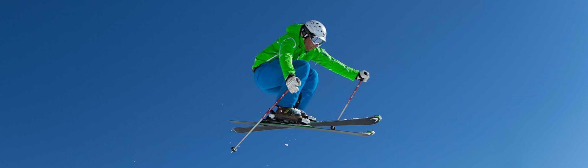 A skier flying through the air during private ski lessons for adults of all levels with ski school Ski Dome Viehhofen.
