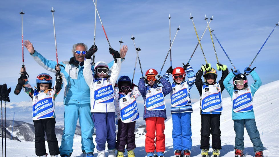 Een groep kinderen lijkt te genieten van hun kinderskilessen (5-14 jaar) - alle niveaus met de skischool Scuola di Sci e Snowboard Prato Nevoso.