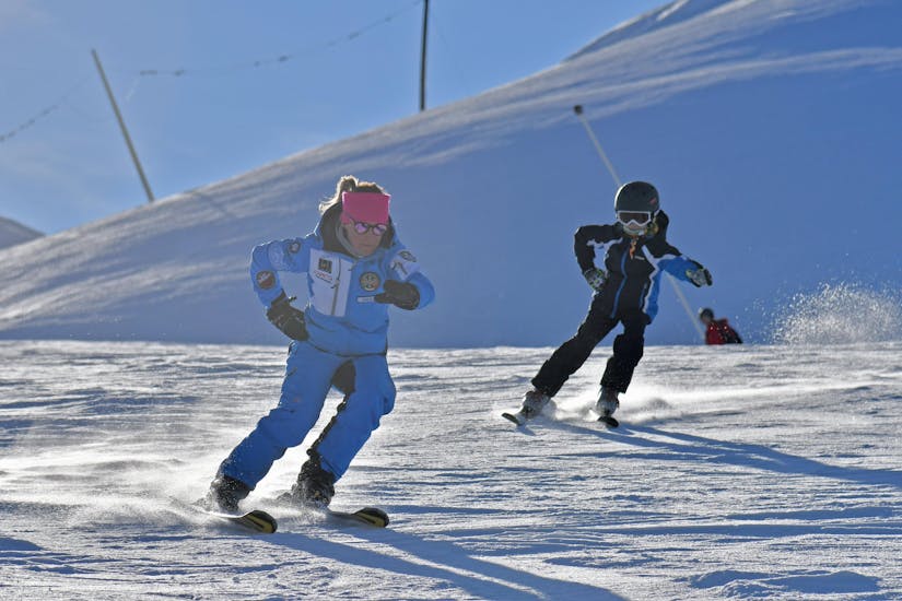 Un moniteur de ski et un participant s'entraînent ensemble sur les pistes de Prato Nevoso pendant l'une des Cours particuliers de ski pour enfants de tous niveaux.