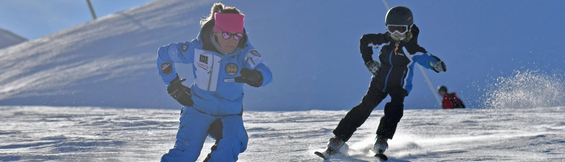 Un moniteur de ski et un participant s'entraînent ensemble sur les pistes de Prato Nevoso pendant l'une des Cours particuliers de ski pour enfants de tous niveaux.