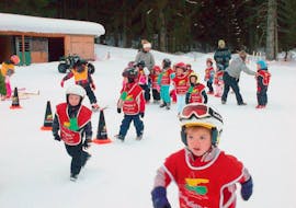 Des enfants jouent ensemble dans la neige durant leurs cours de ski pour enfants - Vacances avec l'école de ski Evolution 2 Chamonix.