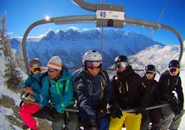 Des adultes sont assis dans le télésiège en direction du sommet de la montagne pour leur cours de ski pour Adultes - 4 jours (Dim-Mer) avec l'école de ski Evolution 2 Chamonix.