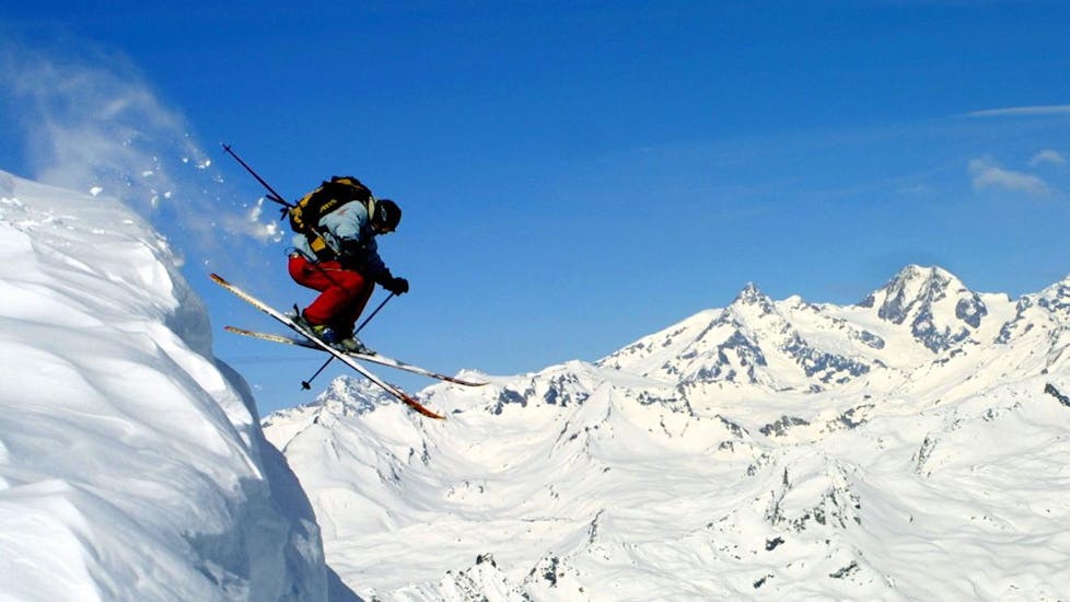 Ein Skifahrer springt während des Privatskikurses für Erwachsene - Alle Levels der Skischule Snocool.