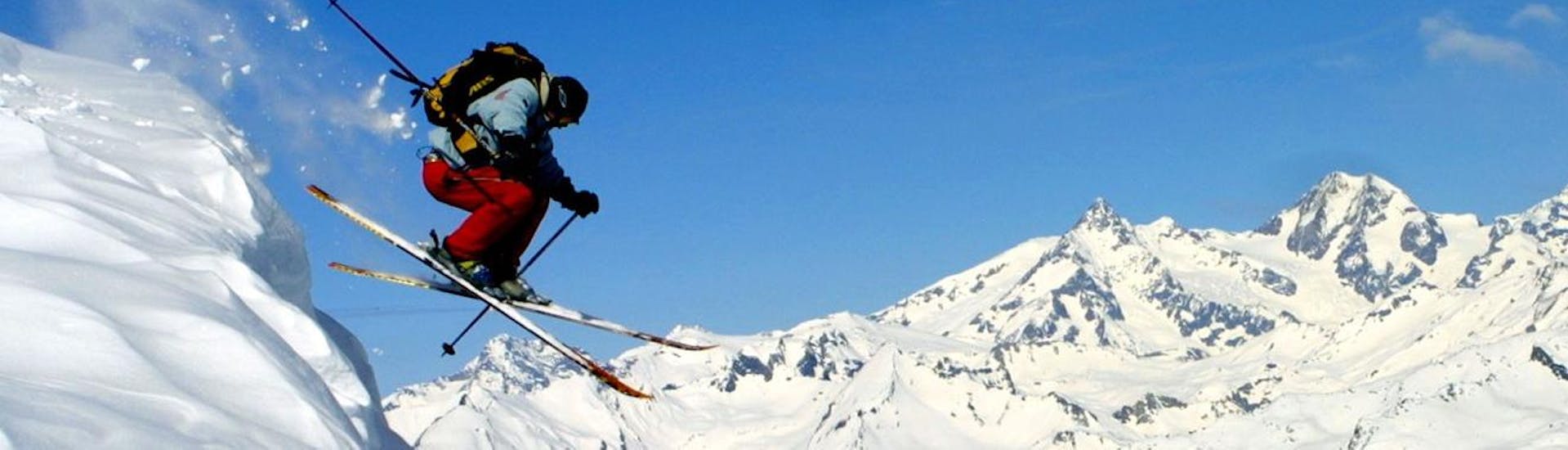 Un skieur fait un saut durant son Cours particulier de ski pour Adultes - Tous niveaux avec l'école de ski Snocool.