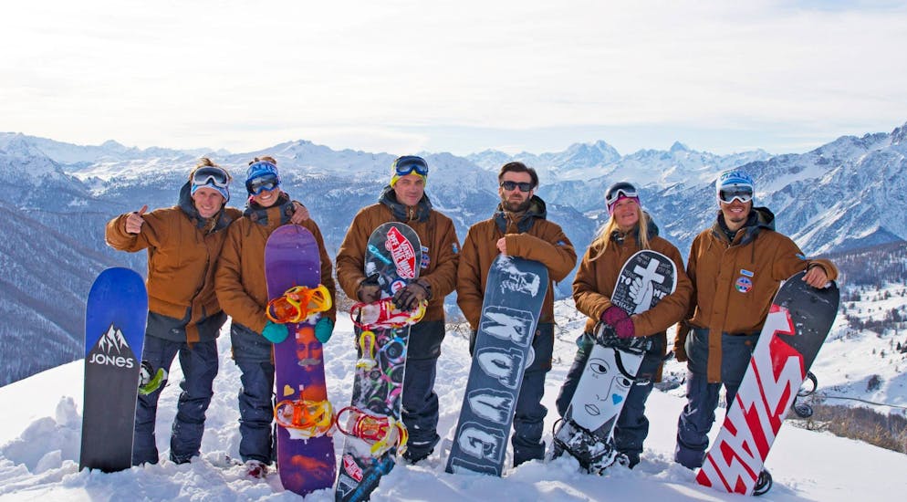 Snowboardleraren poseren voor de foto na een van de snowboardlessen voor kinderen en volwassenen van alle niveaus in Sauze d'Oulx.