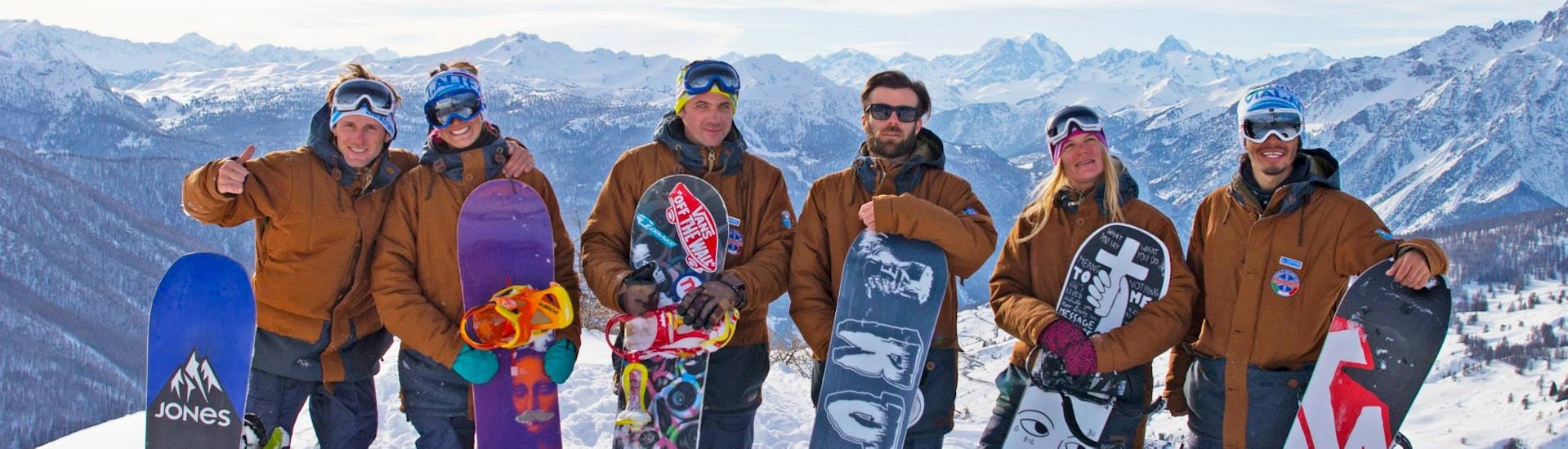 Snowboardlehrer posieren für ein Foto nach einem der Snowboardkurse für Kinder und Erwachsene aller Niveaus in Sauze d'Oulx.