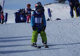 A small child using the snowplough during Private Ski Lessons for Kids of All Ages with Schneesportschule Wildkogel.