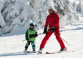 A ski instructor of the Schneesportschule Balderschwang shows a student exercises during his kids ski lessons for first timers.