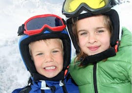 Unos hermanos mejorando sus habilidades de esquí durante las clases particulares de esquí para niños - Todos los niveles, con la escuela de esquí Scuola di Sci e Snowboard Cristallo Cortina.