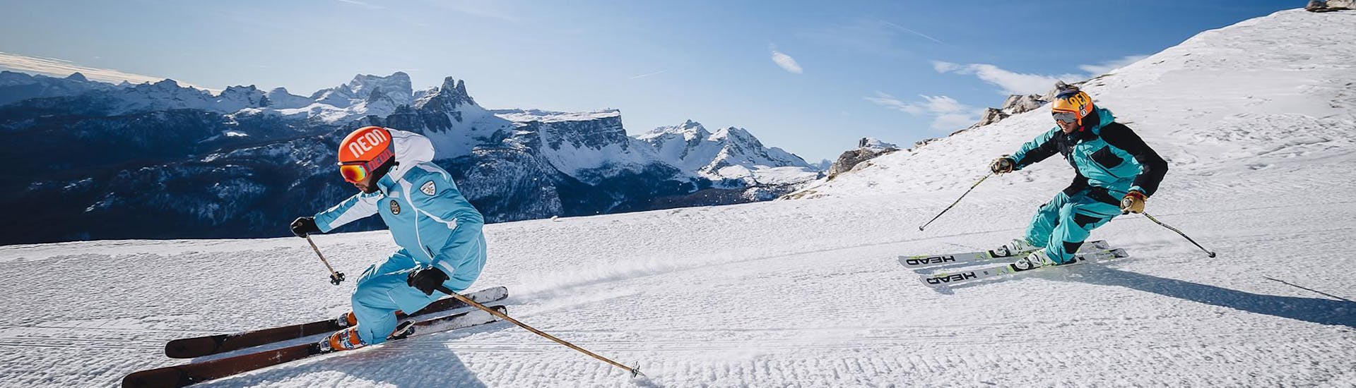 Ein Skilehrer und sein Schützling fahren bei der Aktivität Privater Skikurs für Erwachsene - Anfänger der Skischule Scuola di Sci e Snowboard Cristallo Cortina eine perfekt preparierte Piste in Cortina d'Ampezzo hinunter.