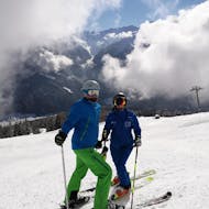 Een skiër en skileraar oefenen op de piste tijdens hun privé-skilessen voor volwassenen van alle niveaus bij Schneesportschule Wildkogel.