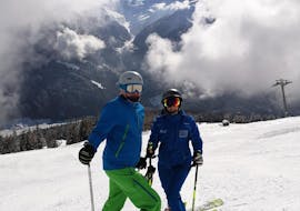 Een skiër en skileraar oefenen op de piste tijdens hun privé-skilessen voor volwassenen van alle niveaus bij Schneesportschule Wildkogel.