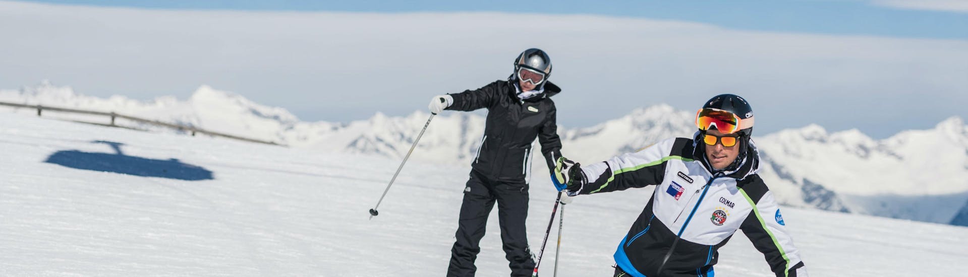 Two happy friends during the adult ski lessons for advanced with Cimaschool Plan de Corones.
