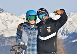 Een blij kind met zijn instructeur tijdens de privé snowboardles met Cimaschool Plan de Corones. 