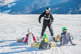 A group of kids listening to the instructor during the kids snowboarding lessons for beginners with Cimaschool Plan de Corones.