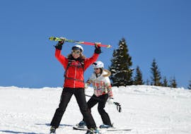 Im Skikurs für Erwachsene - Anfänger zeigt die Skilehrerin der Skischule Kitzbühel Rote Teufel einer Skianfängerin die Grundlagen des Pflugfahrens.