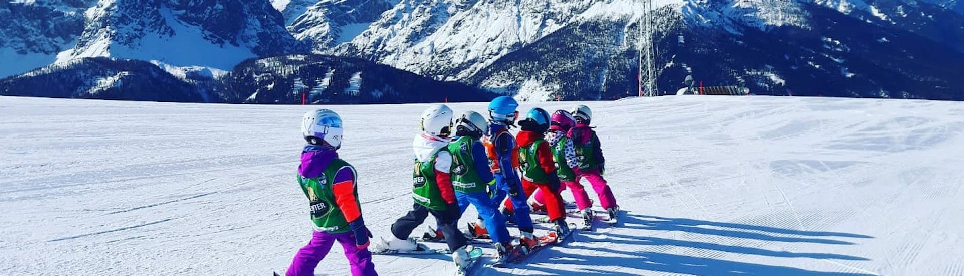 Kids waiting to perform one of the exercises during one of the kids ski lessons for all levels in Monte Elmo.