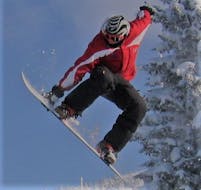 A snowboarder is showing off some impressive tricks during their Snowboarding Lessons for Kids (8-14 years) - Intermediate with the ski school Skischule Lechner in Zell am Ziller.