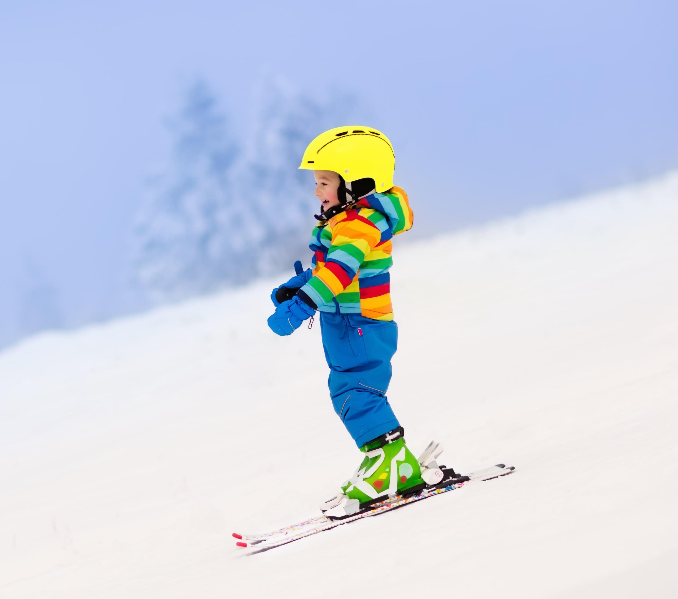Ein Kind genießt sein erstes Mal auf dem Schnee in Monte Elmo während eines der privaten Skikurse für Kinder aller Stufen.