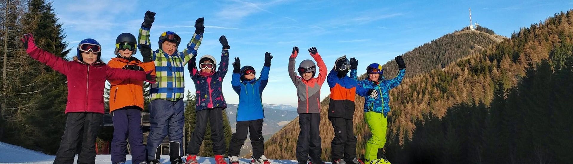 A group of kids cheering during their Kids Ski Lessons (5-17 y.) for Skiers with Experience.