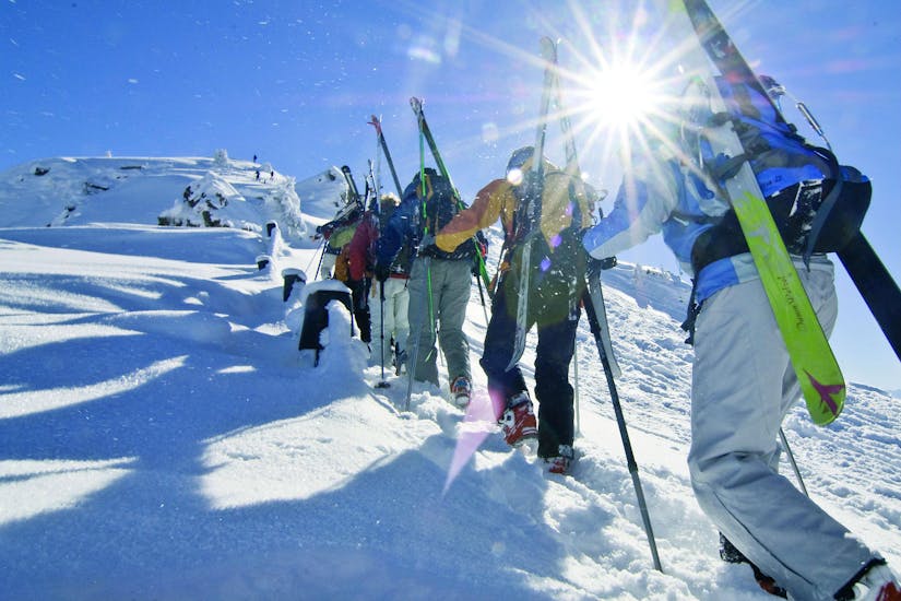 Mensen volgen een toerskiëngids van skischool Club Alpin in Grän.