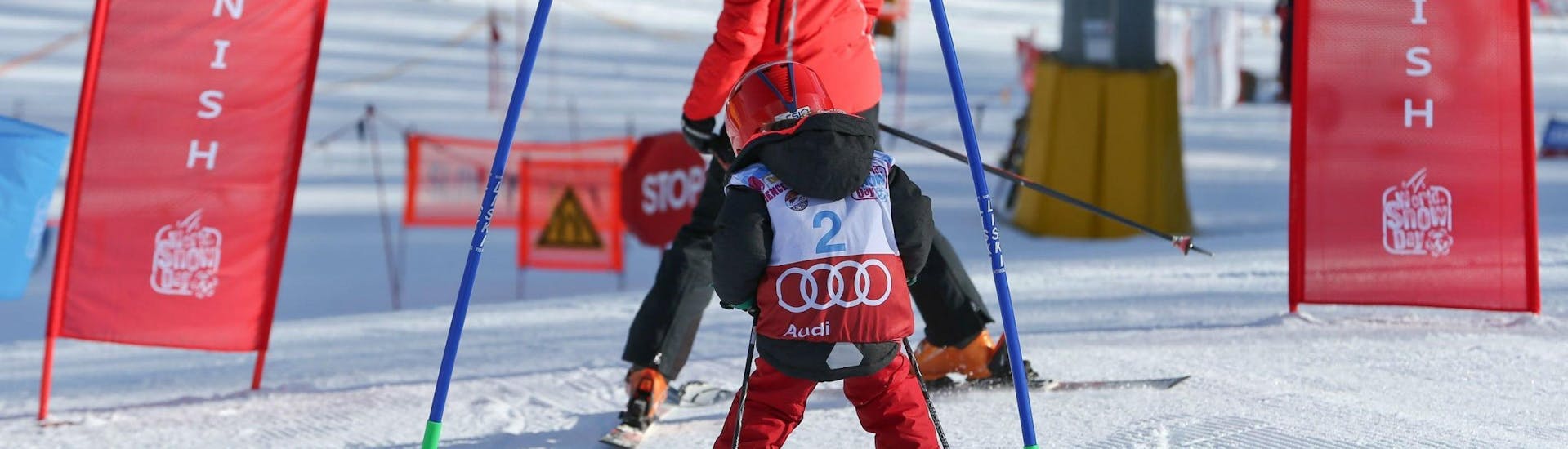 A young child is practicing its skiing technique on a race course in Cortina d'Ampezzo during one of its Kids Ski Lessons "Smart" (4-12 years) - With Experience organised by the ski school Scuola Sci Cortina.