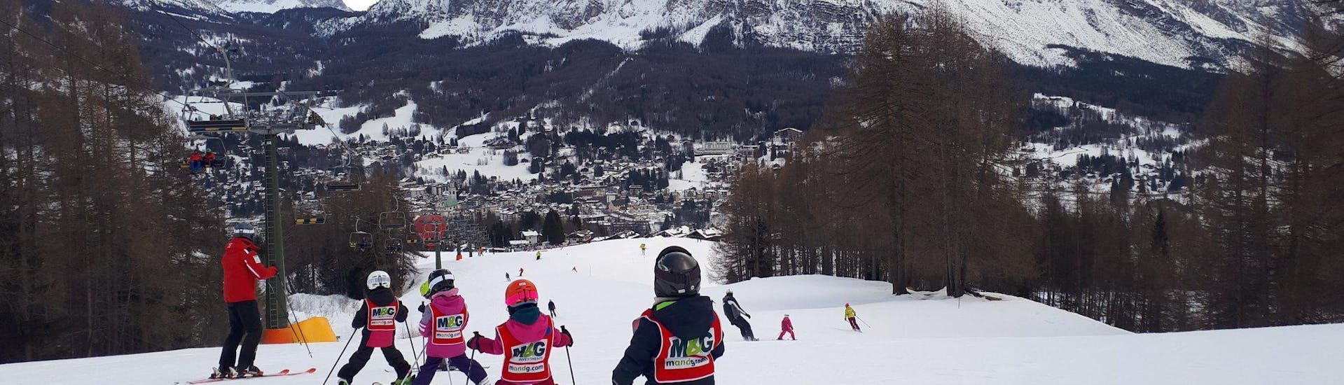 Des enfants suivent de près le moniteur de ski à Cortina pendant l'un des cours de ski pour enfants (4-10 ans) pour débutants.