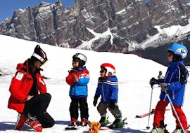 Due bambini piccoli imparano a sciare con una maestra premurosa della Scuola Sci Cortina durante Lezioni di sci per bambini (4-10 anni) - Senza Esperienza.