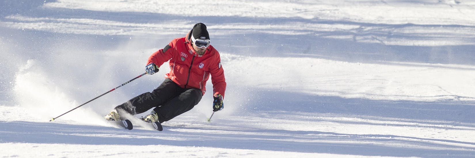 Un moniteur de ski de la Scuola Sci Cortina fait la démonstration de la bonne technique de ski pendant l'un des cours d'initiation au ski pour adultes dans la station de ski de Cortina d'Ampezzo.