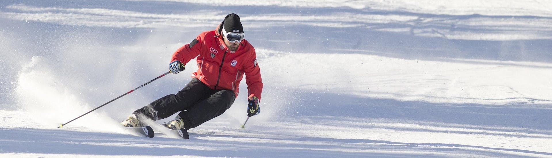 Un istruttore di sci della scuola di sci Scuola Sci Cortina sta mostrando la giusta tecnica di sci durante una delle lezioni di sci per adulti - principianti assoluti nel comprensorio sciistico di Cortina d'Ampezzo.