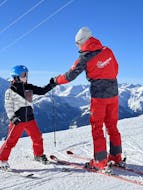 During the private ski lessons for kids and teens of all levels, a ski instructor from Skischule Arena Zell am Ziller and his student are doing a fist bump on the slopes.