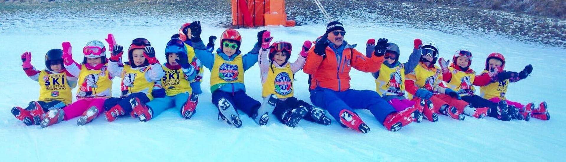Maestro di sci con i bambini alla fine di una delle lezioni di sci per bambini (3-14 anni) per tutti i livelli con Sporting Al Plan. 