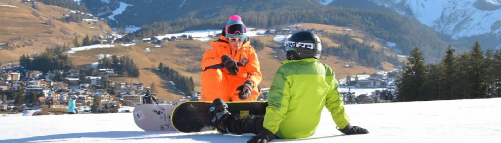 A snowboard instructor is giving some tips to a participant during one of the snowboarding Lessons for Kids and Adults of All Levels with Sporting al Plan