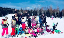 Een blije groep skiërs tijdens de skilessen voor kinderen (6-12 jaar) voor beginners bij Skischool VIP Špindlerův Mlýn.