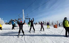 Een blije groep skiërs oefent tijdens hun skilessen voor kinderen (6-12 jaar) voor gevorderden bij Skischool VIP Špindlerův Mlýn.