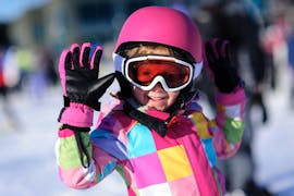 Een blij meisje in de sneeuw tijdens de kinderskilessen + skiverhuurpakket voor gevorderden bij Skischool VIP Špindlerův Mlýn.