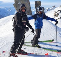 Un esquiador y su instructor de la escuela de esquí Ski Cool Val Thorens están parados en la cima de una pendiente, para sus clases particulares de esquí para adultos de todos los niveles - En la mañana.