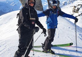Un skieur et son moniteur de l'école de ski Ski Cool Val Thorens se tiennent au sommet d'une piste, pour leur Cours particulier de ski Adultes - Matin.