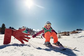 Bambino da il cinque al maestro a San Cassiano dopo una delle lezioni private di sci per bambini per tutti i livelli.