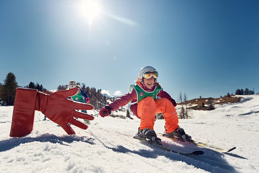Bambina da il cinque ad Armentarola durante una delle Lezioni private di sci per bambini per tutti i livelli.