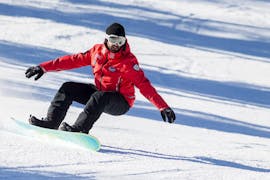Un snowboarder sur une piste enneigée pendant les cours de snowboard pour enfants et adultes - tous niveaux de l'école de ski Scuola Sci Cortina.